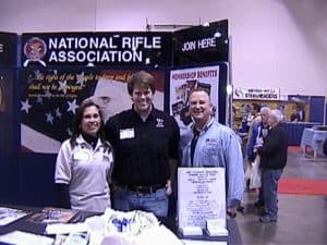 Mary & Al Polkowski with NRA Official at Outdoorama recruiting booth as 3 time National Top Ten Recruiters for the NRA